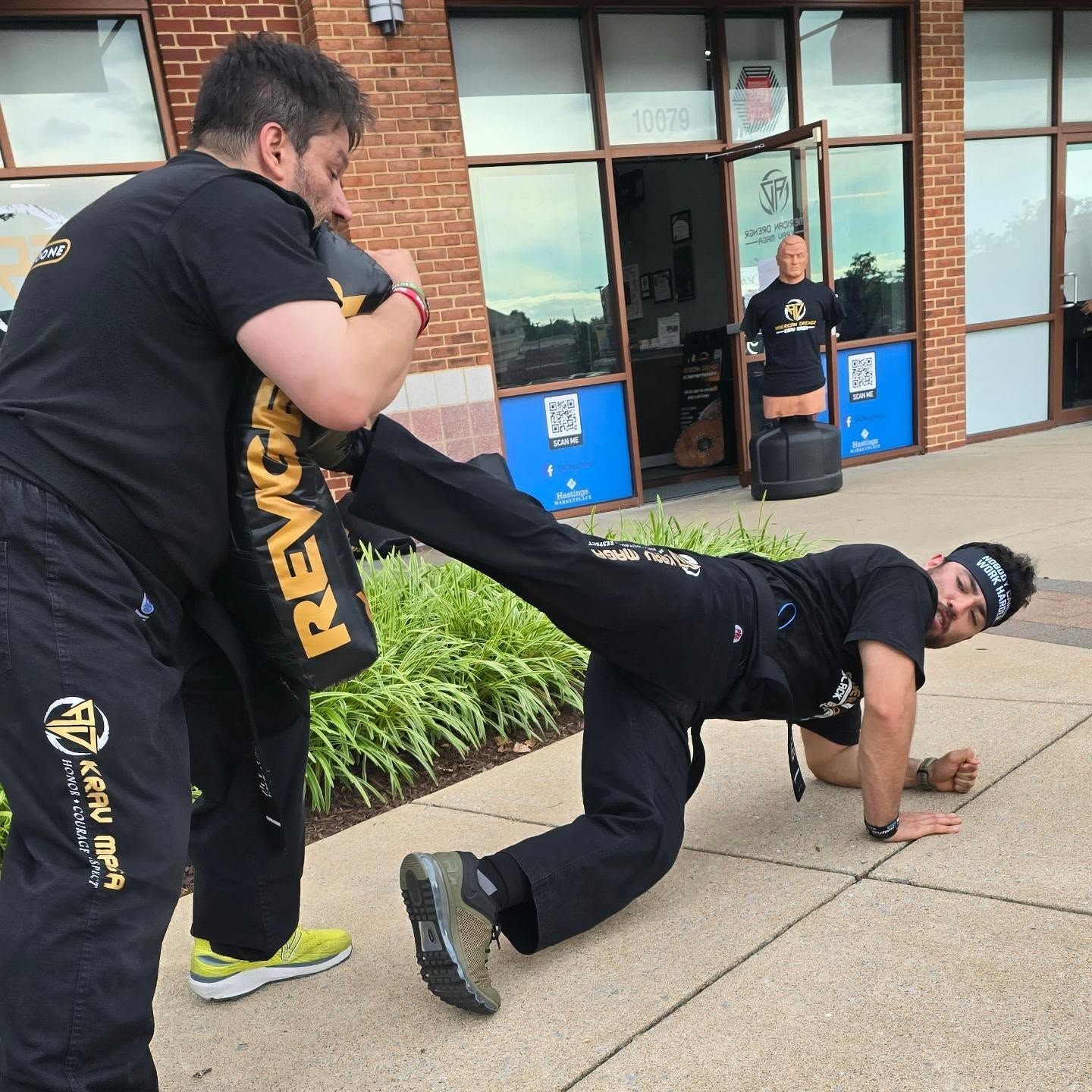 Two people practicing Brazilian Jiu-Jitsu on a mat. One is on top, applying a hold.