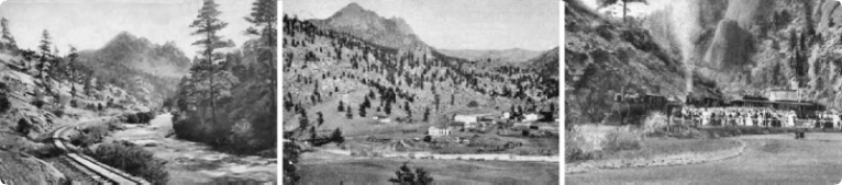 Panoramic black and white landscape of mountains, valley, and buildings.