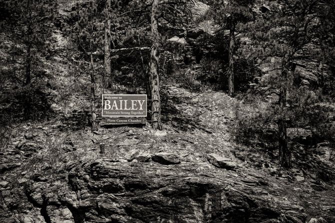 Sign for the Bailey real estate agency posted on a rocky hillside. Black and white.