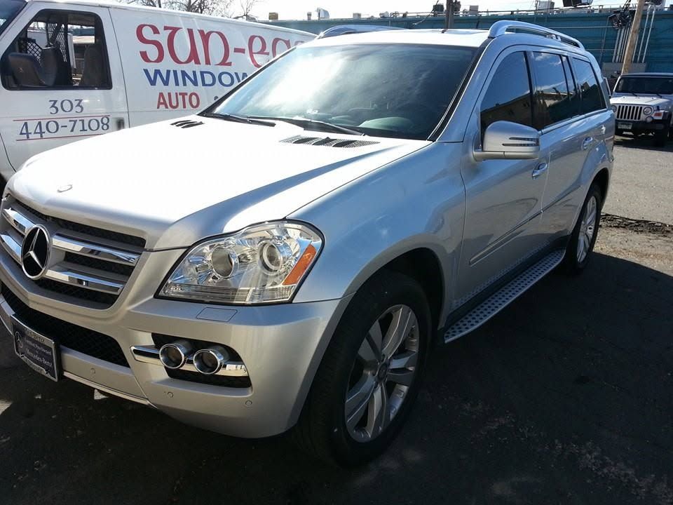 Silver Mercedes SUV parked at a dealership lot with a Sun Auto sign in the background