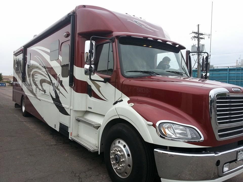 Maroon and white semi-truck parked outdoors on a paved lot
