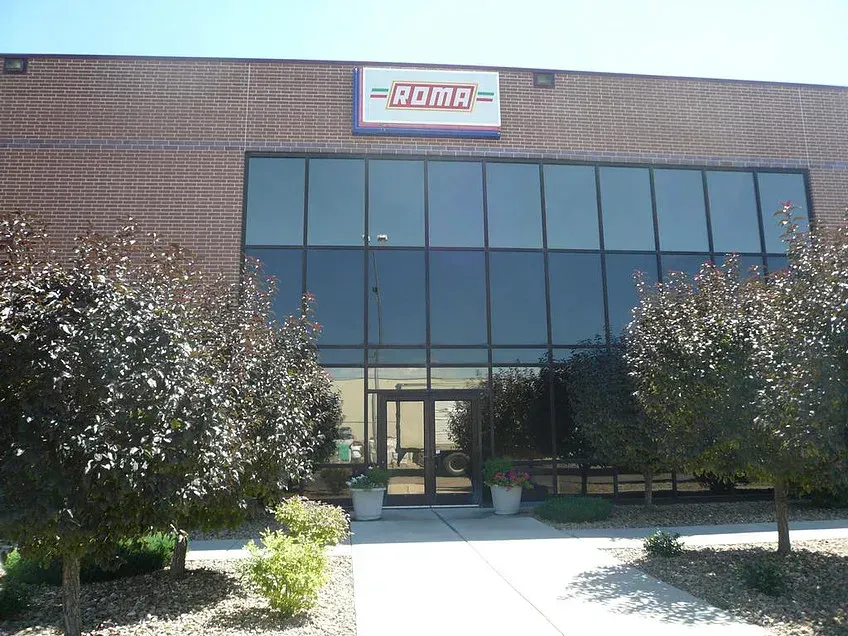 Brick building entrance with large windows and an ADA ramp leading to double glass doors