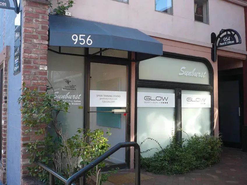 Storefront with black awning marked “956,” glass windows, and a small sign near the entrance.