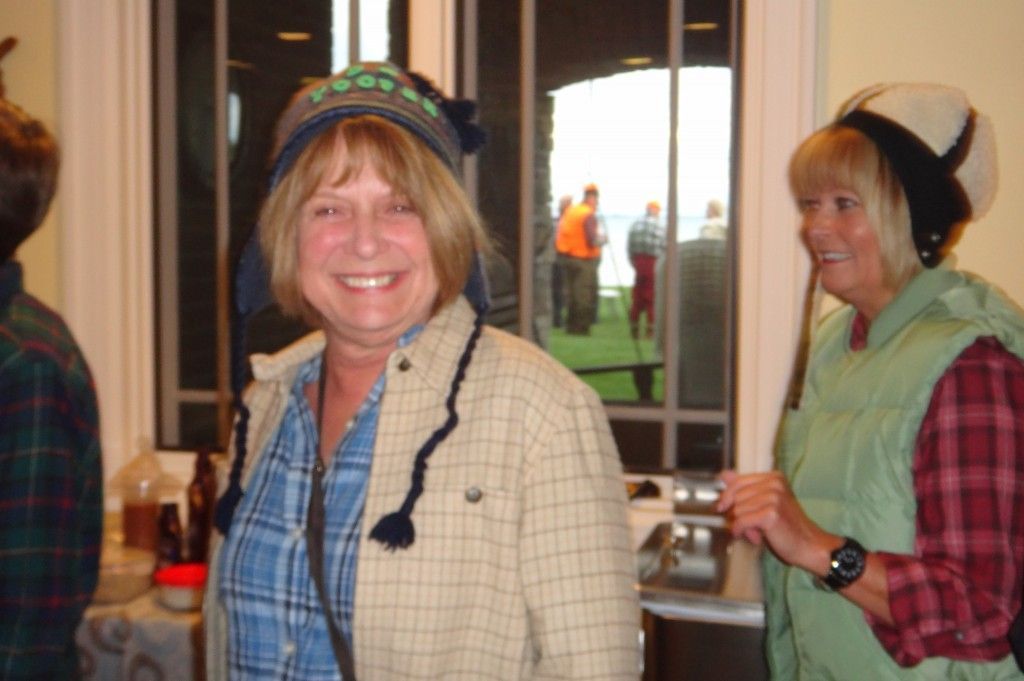 A woman wearing a plaid shirt and a beanie smiles for the camera.