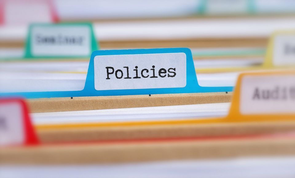 A folder with the word policies written on it.
