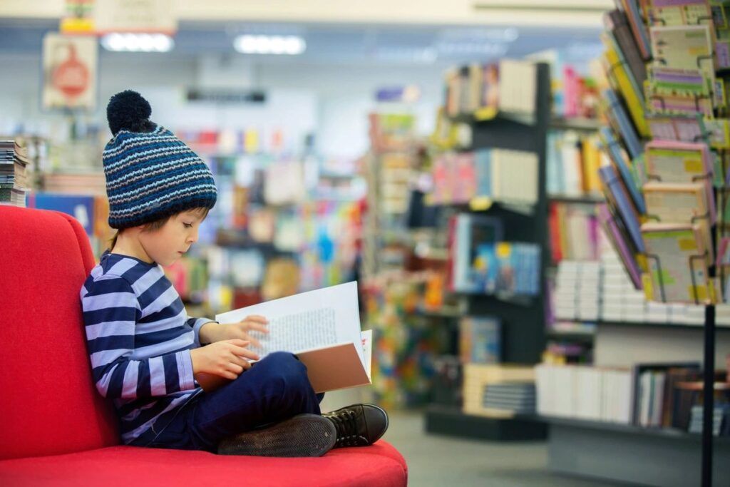 Kid reading in a library.