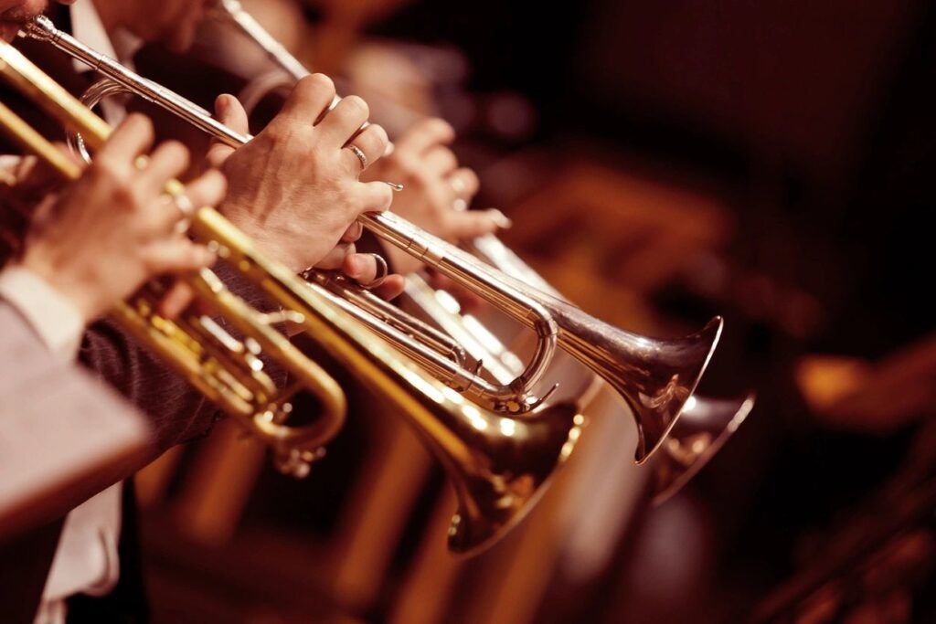 A group of people playing trumpets in an orchestra.