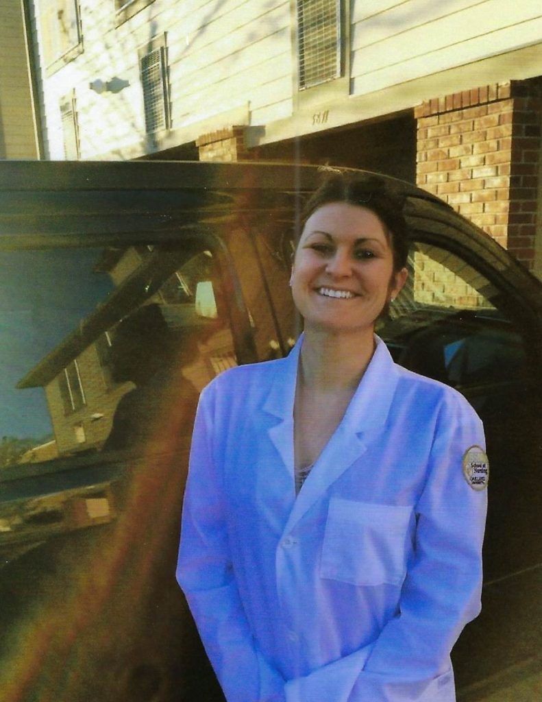 A woman standing outside next to a car.