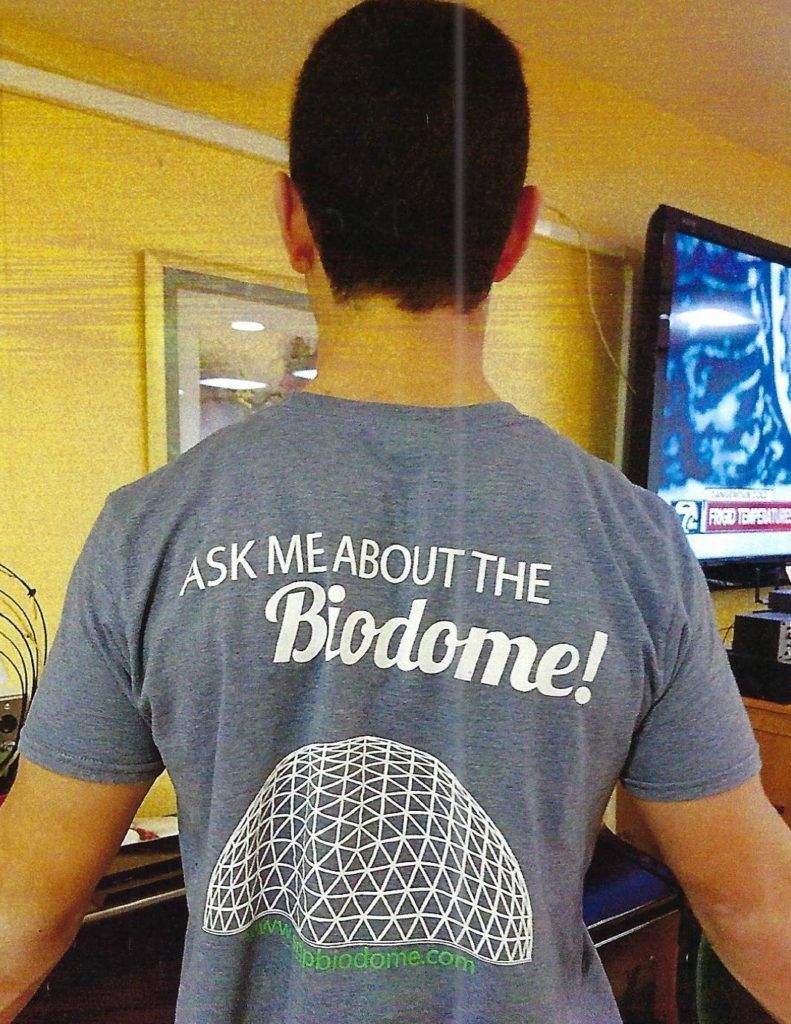 A man wearing a shirt that says ask me about the biodome.