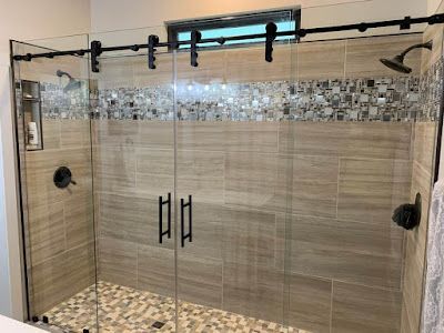 A bathroom with a sliding glass shower door and a tiled floor.