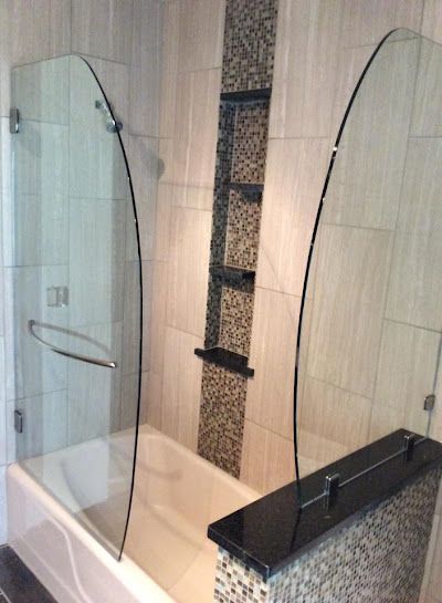 A bathroom with a bathtub and a glass shower door