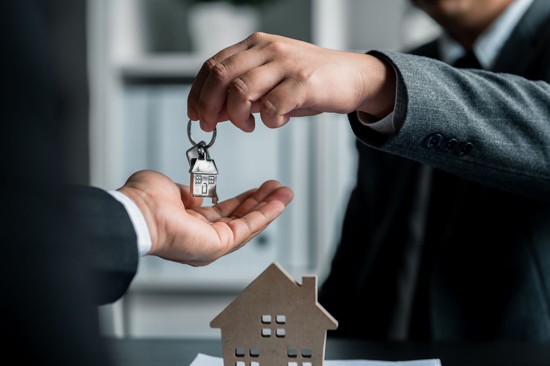 Estate agent delivers keys is the new home to a customer.