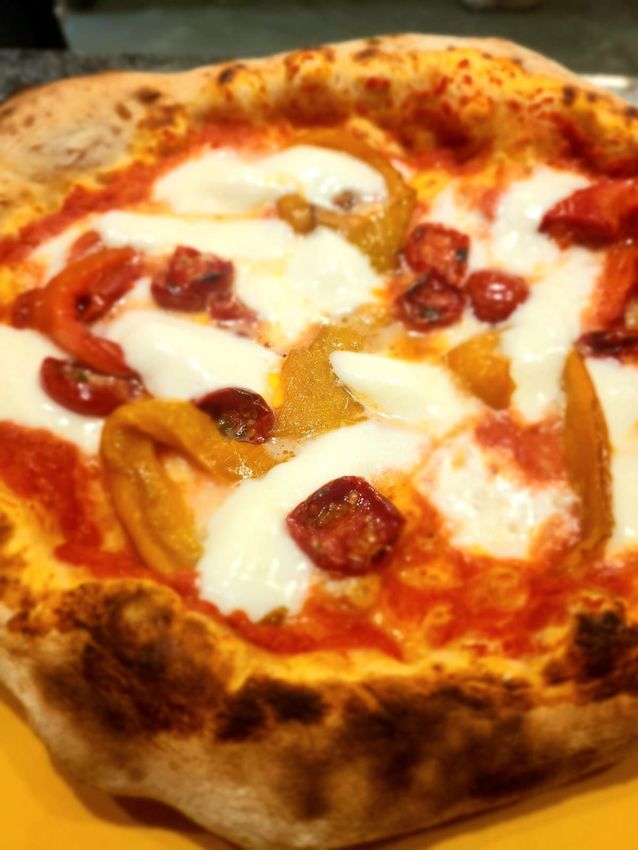 Primo piano di una pizza al formaggio con salsa di pomodoro e salame piccante sulla base.