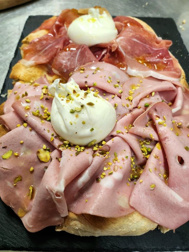 Tramezzino aperto con prosciutto crudo, prosciutto cotto a fette, burrata e pistacchi su pane