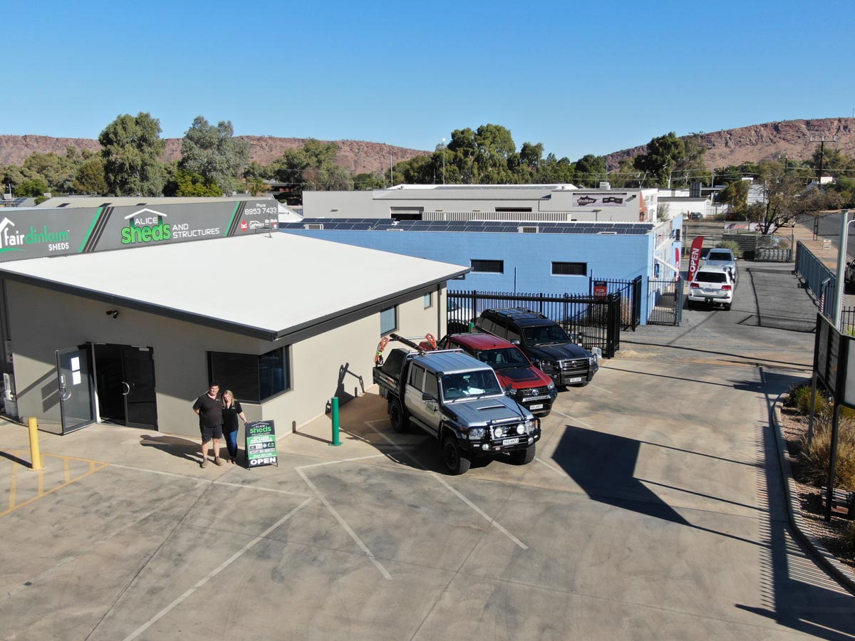 An Aerial View Of A Parking Lot With Cars Parked In Front Of A Building — Alice Sheds & Structures In Ciccone, NT