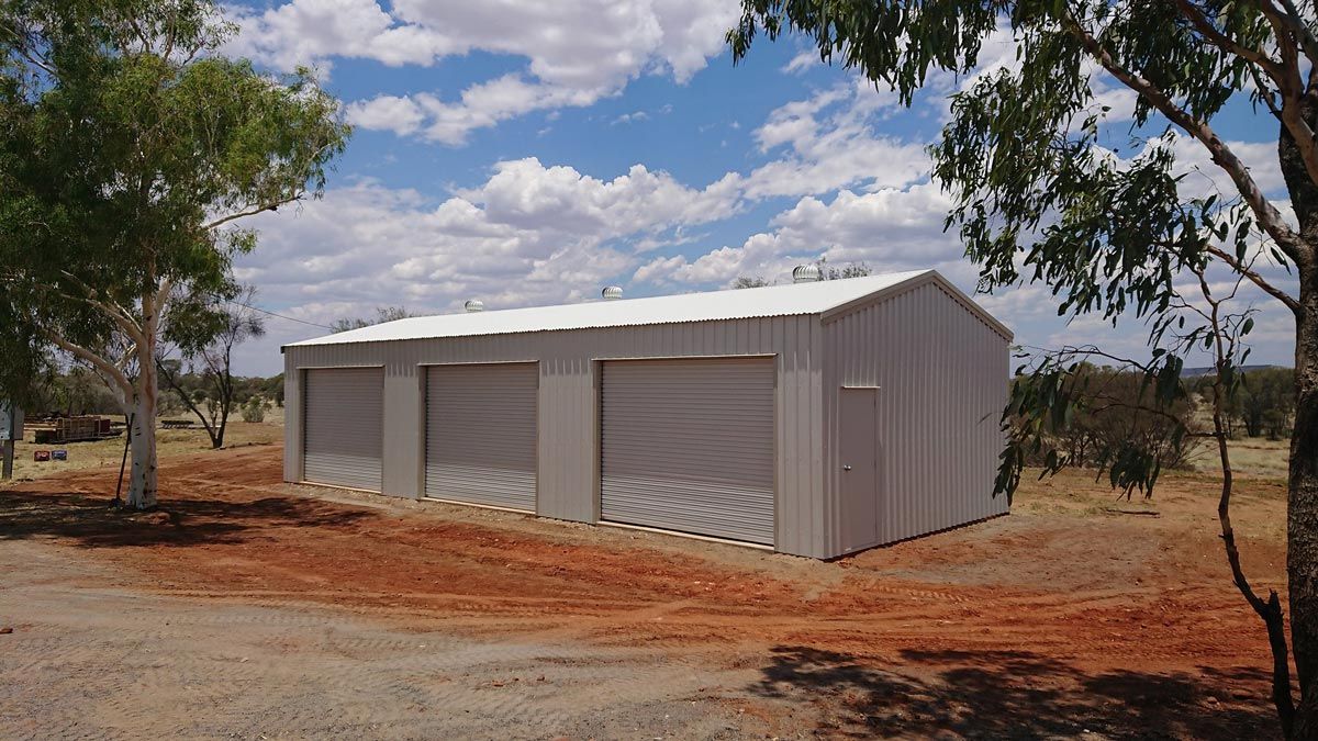 A Grey Shed With Roller Doors — Alice Sheds & Structures In Ciccone, NT