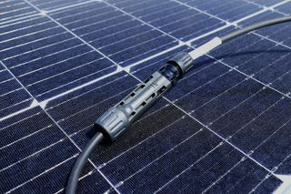 Solar panel connectors plugged into a blue photovoltaic panel array