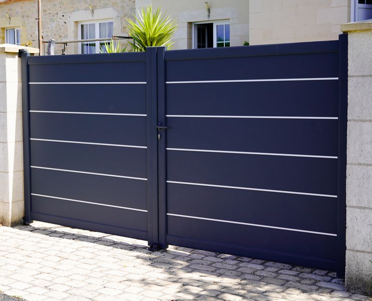 Dark Blue Double Metal Gate in A White Stone Wall in Front of A House — Coastal Auto Garage Doors & Gates In Burpengary, QLD