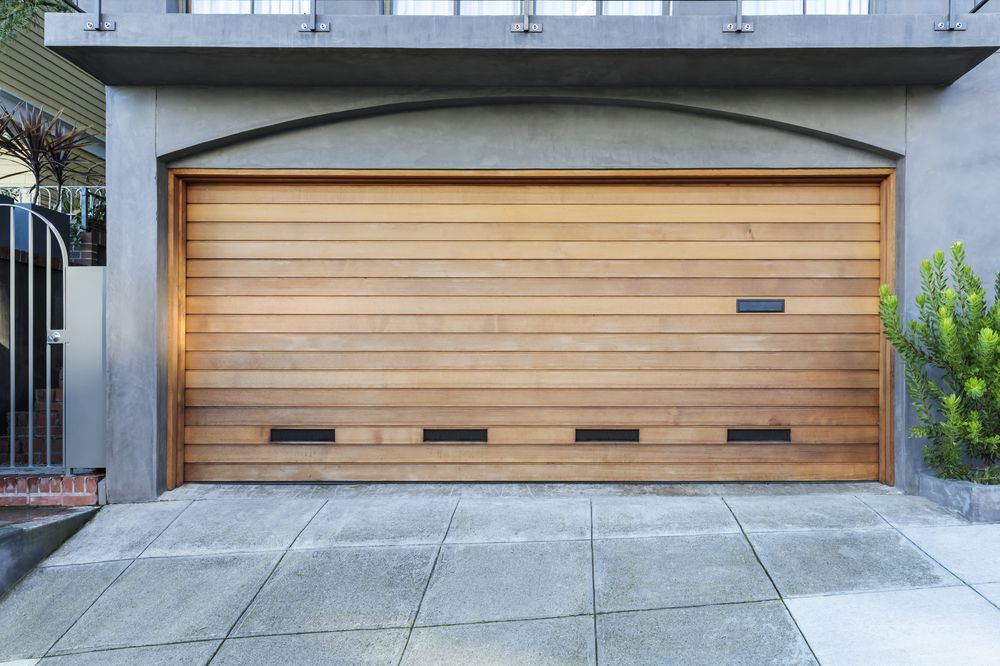 Wooden Garage Door Set in A Modern Concrete Driveway — Coastal Auto Garage Doors & Gates In North Lakes, QLD