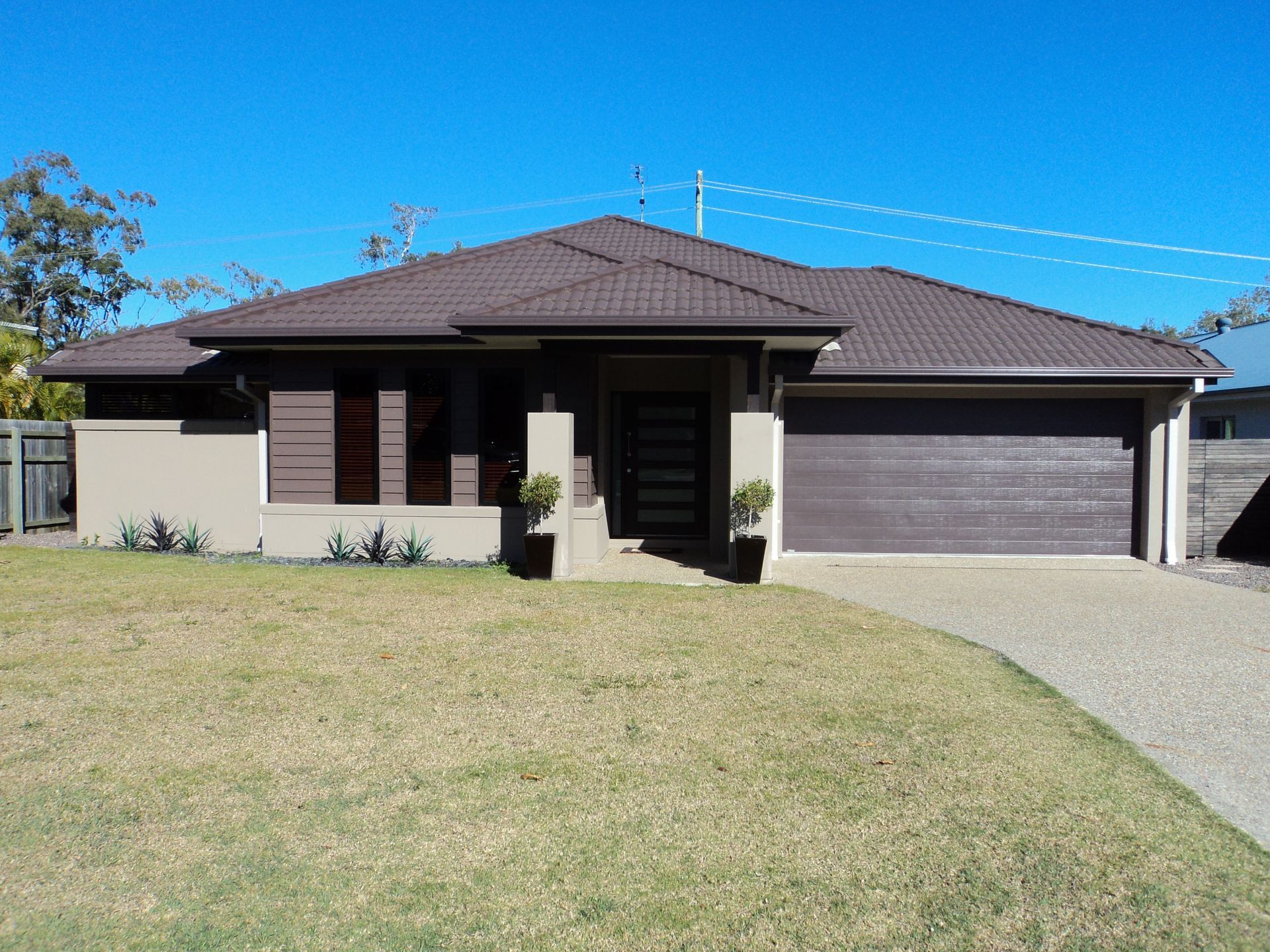 Brown Roofed House With a Brown Garage Door — Coastal Auto Doors & Gates In Nambour, QLD
