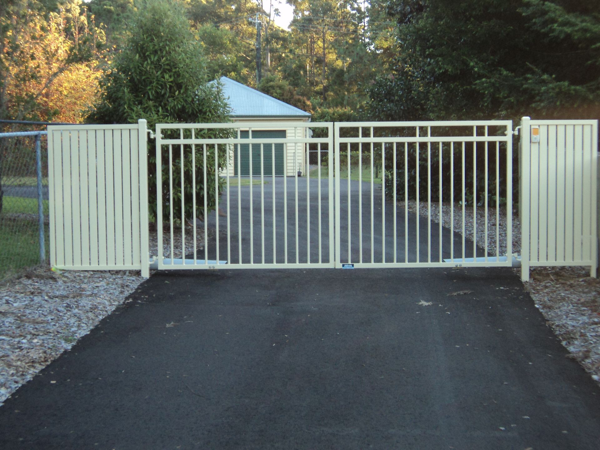 Tan Metal Gate Across a Paved Driveway — Coastal Auto Doors & Gates In Palmwoods, QLD