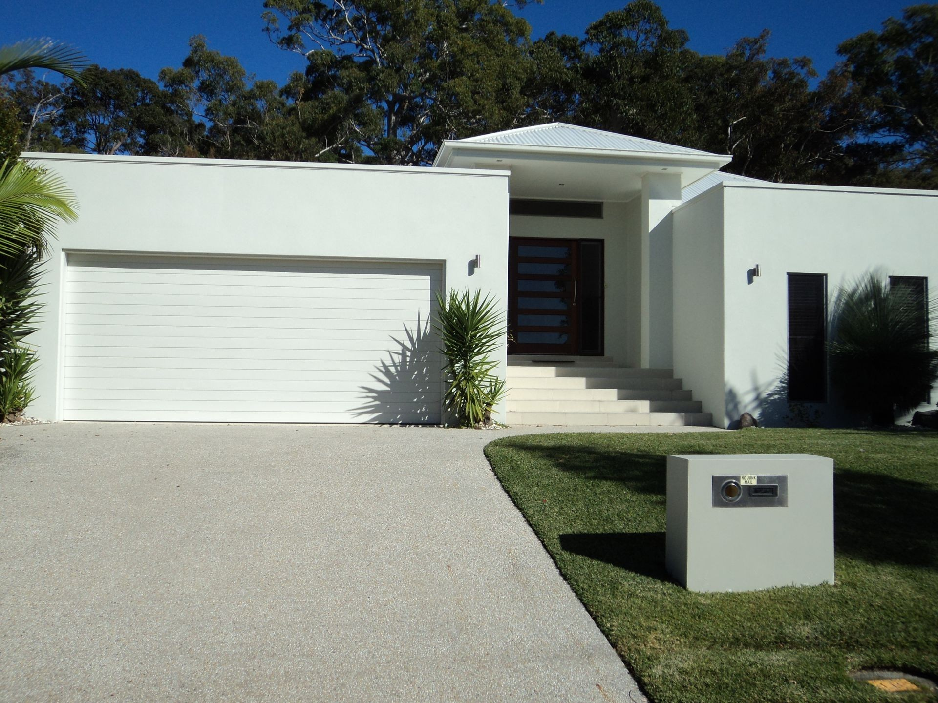 White Modern Home With Driveway, Garage, and Front Door; Sunny Day — Coastal Auto Doors & Gates In Palmwoods, QLD