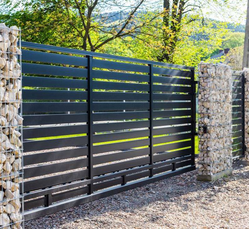 A Metal Sliding Gate with Rock Walls — Coastal Auto Garage Doors & Gates In Morayfield, QLD