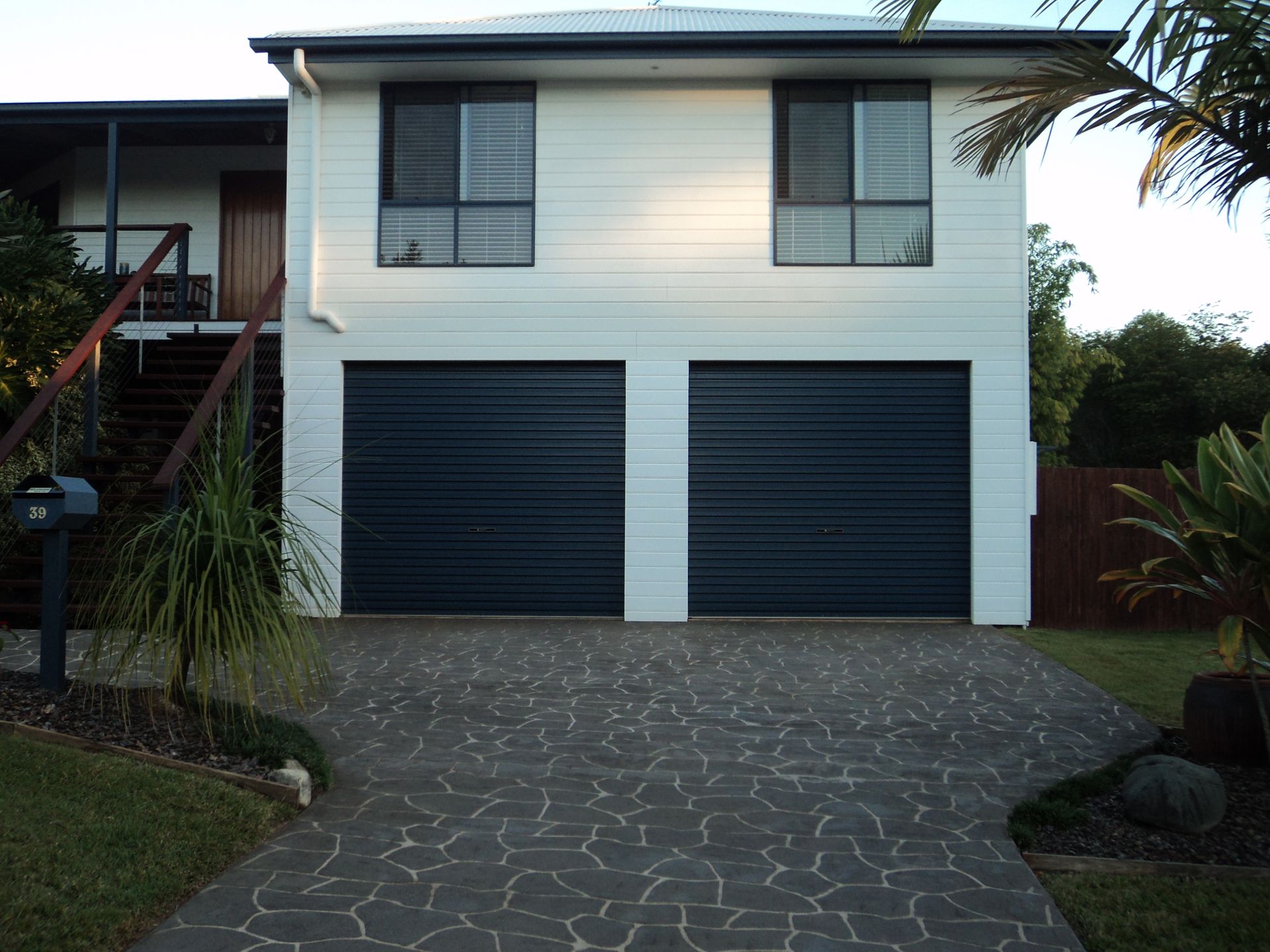 Two-story House With White Siding and Dark Gray Garage Doors — Coastal Auto Doors & Gates In Maroochydore, QLD