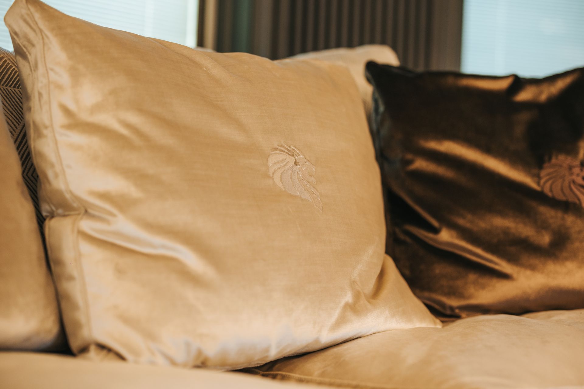 Cream and brown velvet throw pillows on a couch.