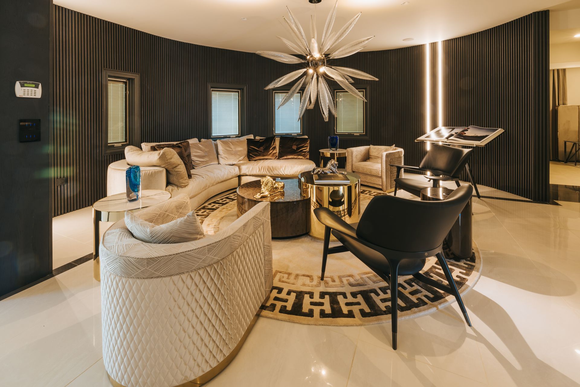 Luxurious living room with plush, curved sofas, ornate decor, and a statement chandelier.