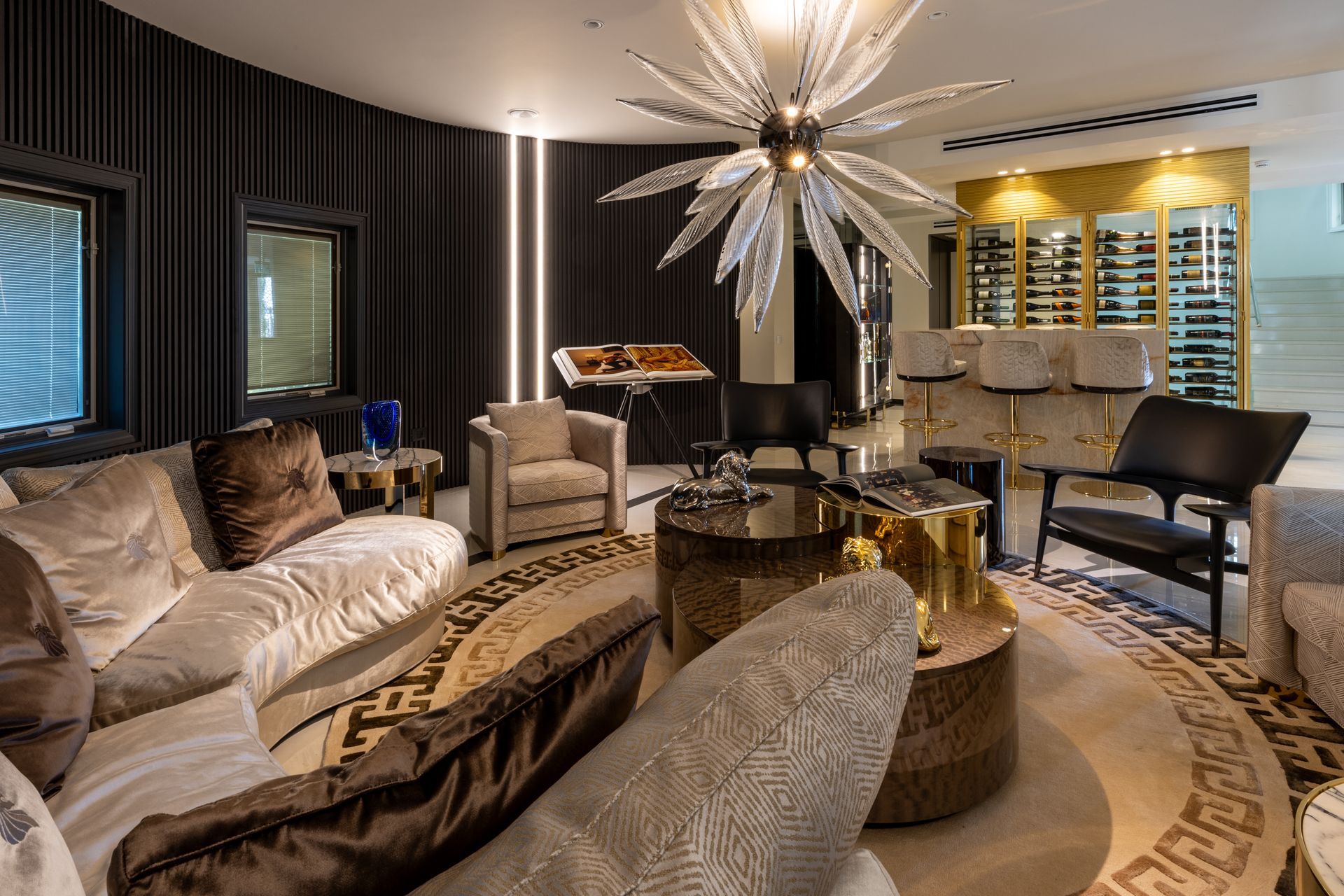 Luxurious living room with curved sofa, gold accents, and a wine bar.