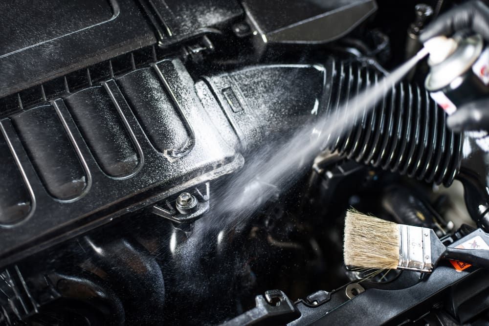 Spraying Cleaner on a Black Car Engine Component — Burcher EFI & Service Centre in Orange, NSW
