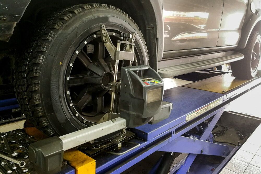 Car Wheel on a Lift Undergoing Alignment — Burcher EFI & Service Centre in Orange, NSW