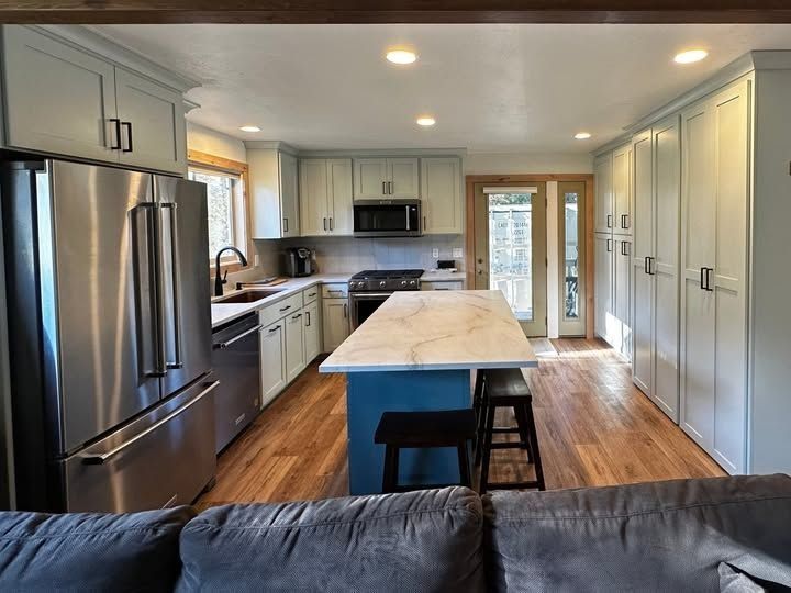 Bright Modern Kitchen with Stainless Steel Appliances, White Cabinets, and A Central Island with Stools in Twin Falls, ID