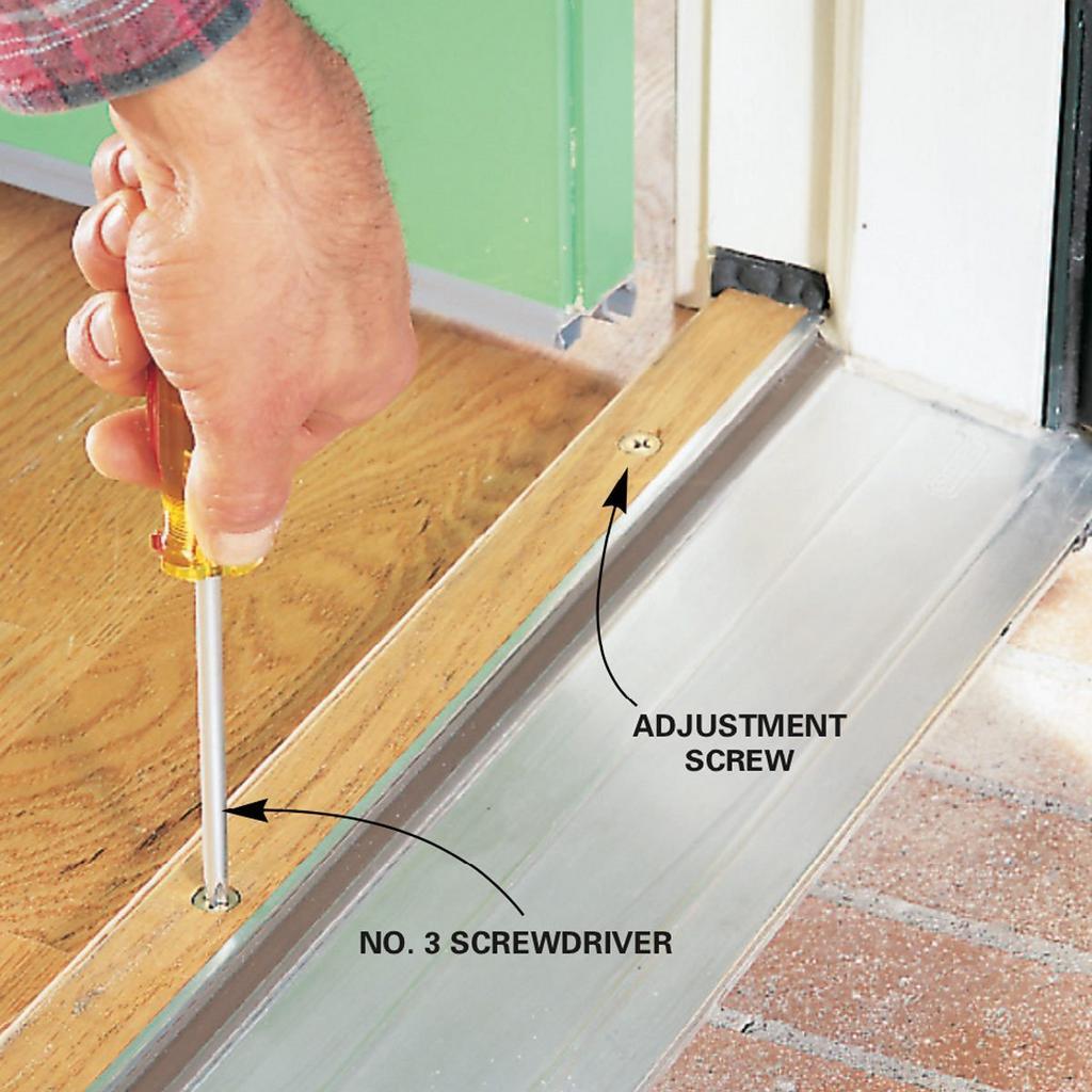 A person is using a screwdriver to adjust a door sill