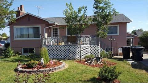 A pink house with a large lawn in front of it