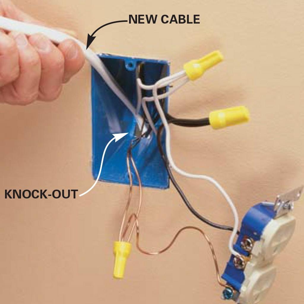 A person is plugging a new cable into an outlet