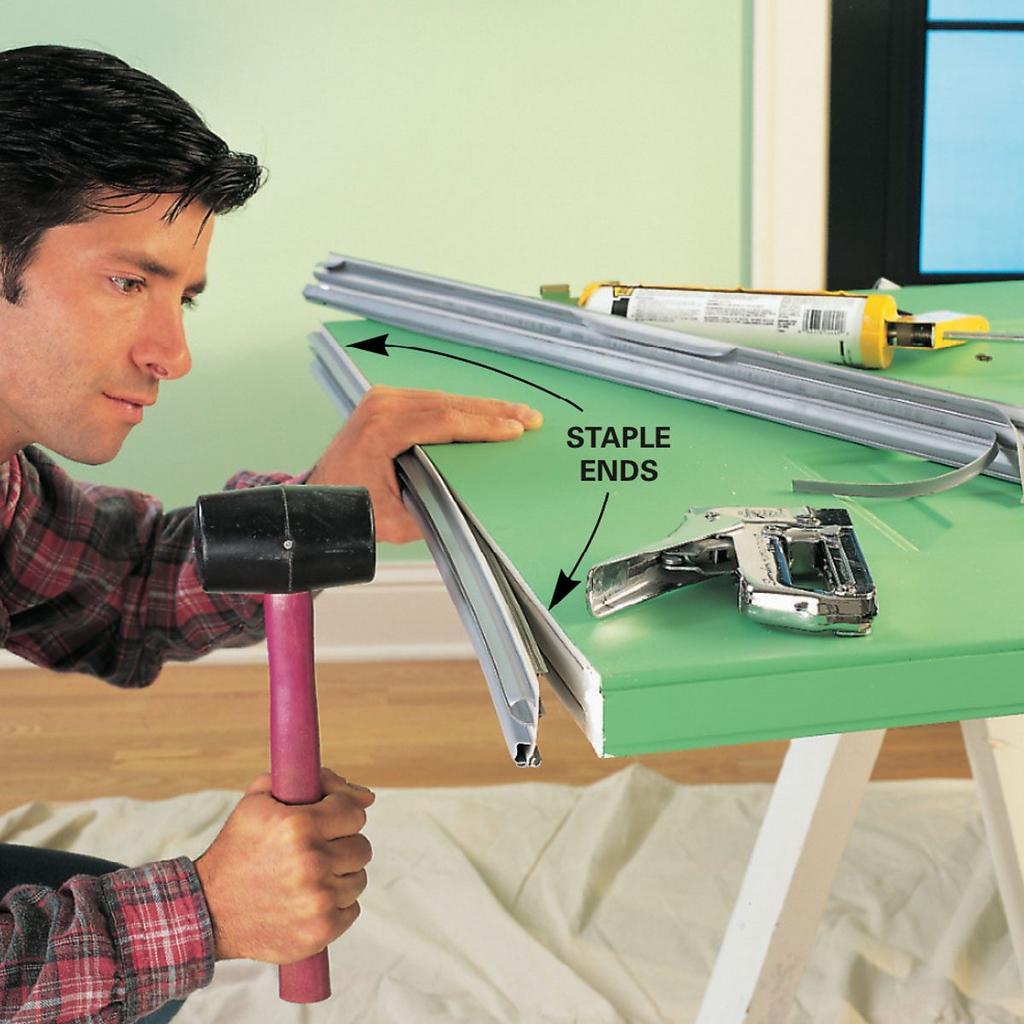 A man is using a hammer to staple a piece of paper