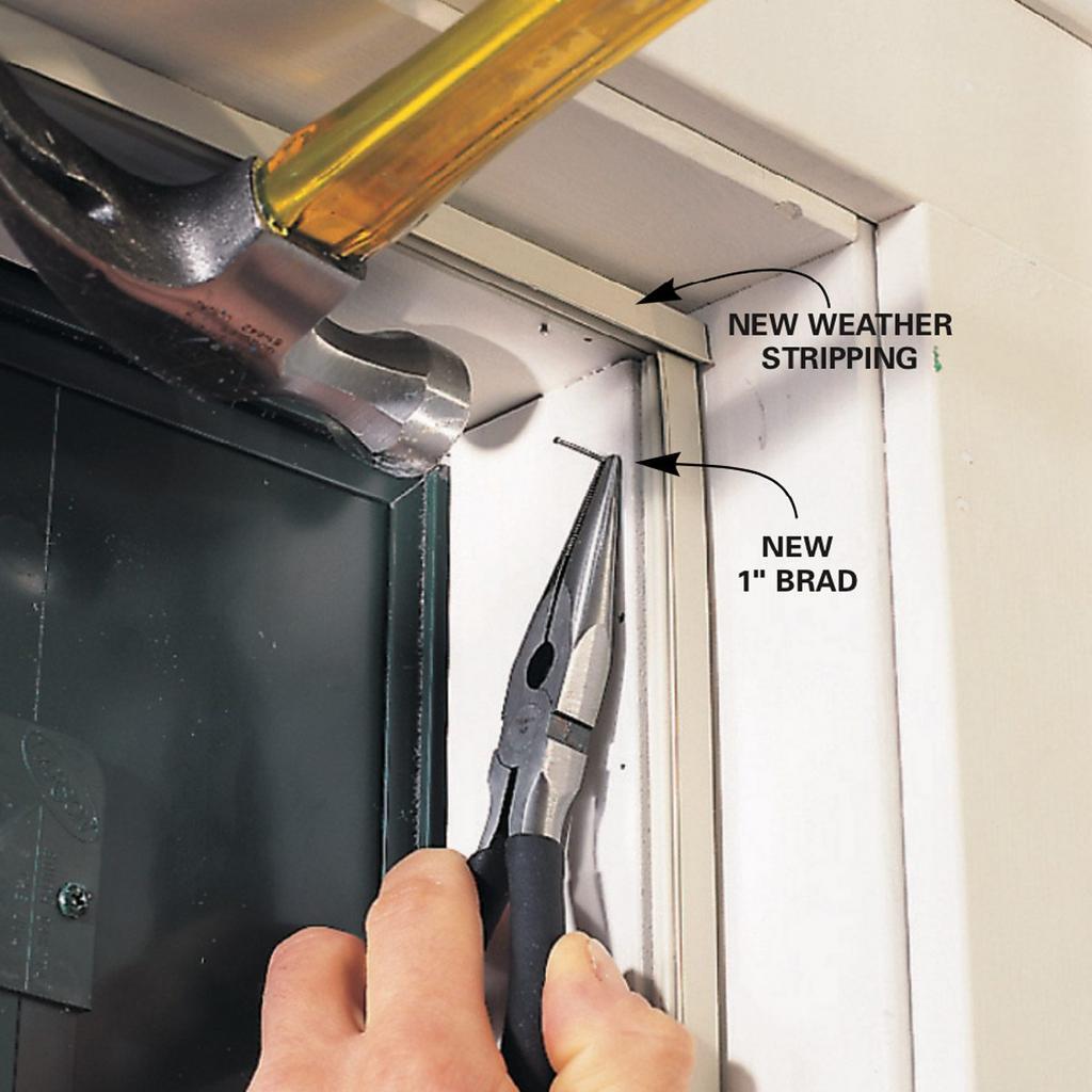 A person is stripping a door with a pair of pliers and a hammer