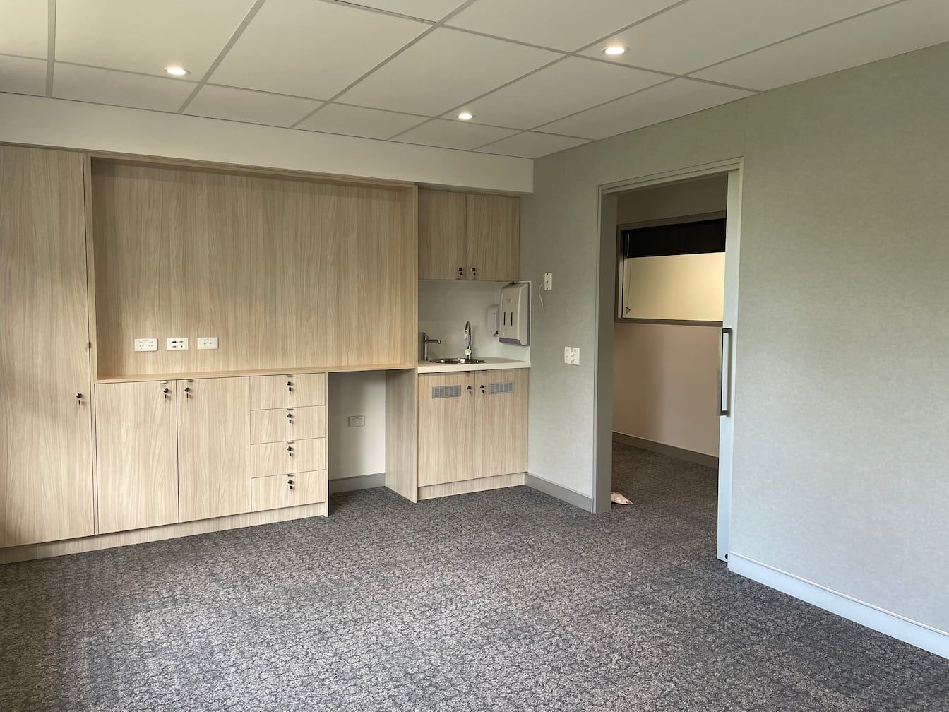 an empty room with wooden cabinets and a sink
