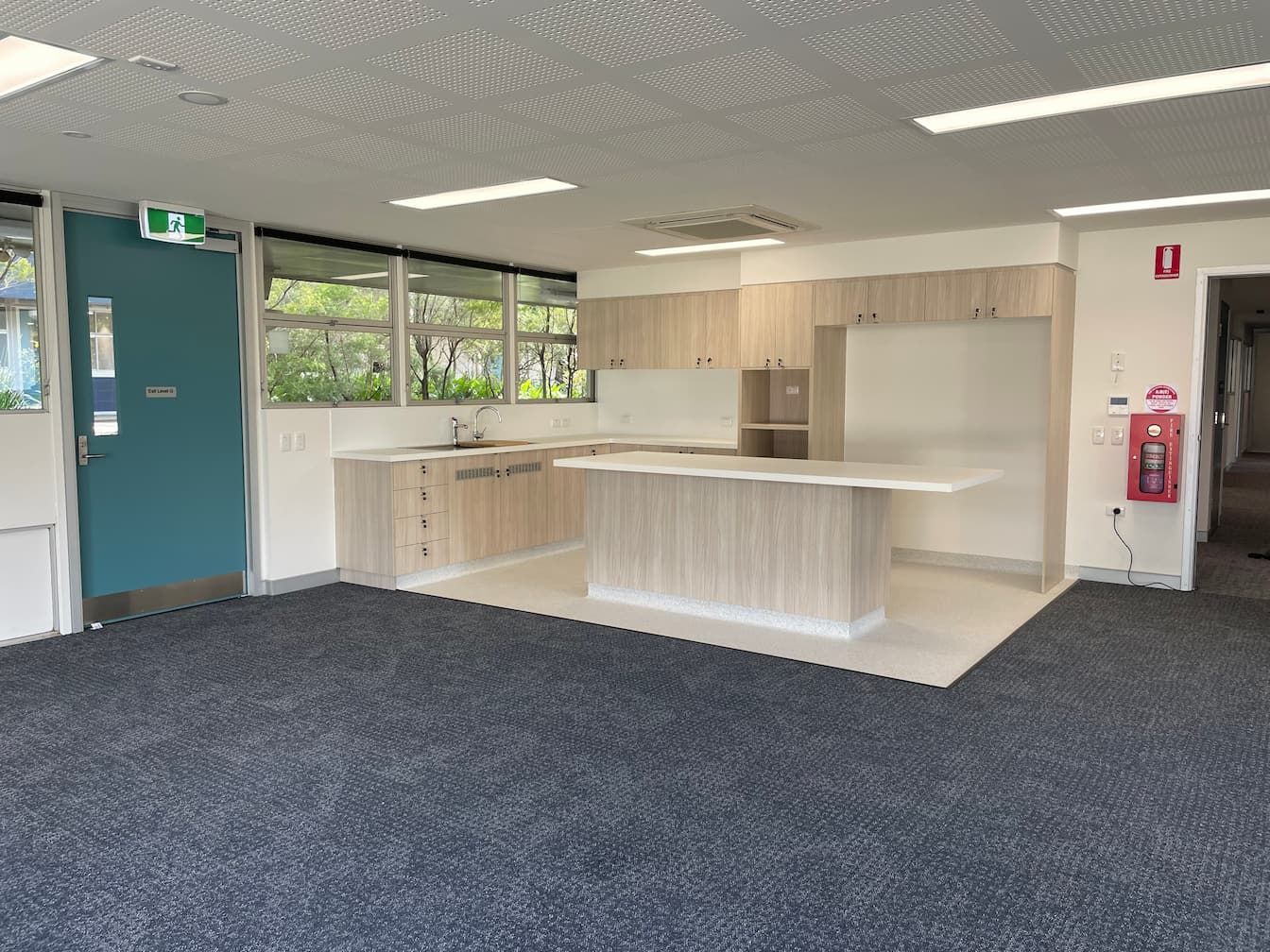 an empty kitchen with a fire extinguisher on the wall