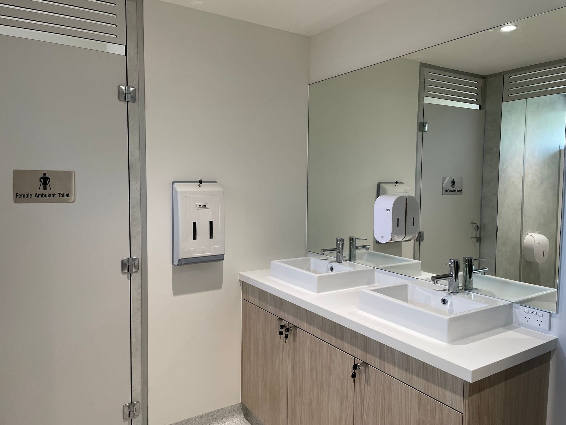 a bathroom with two sinks and a sign that says female changing station