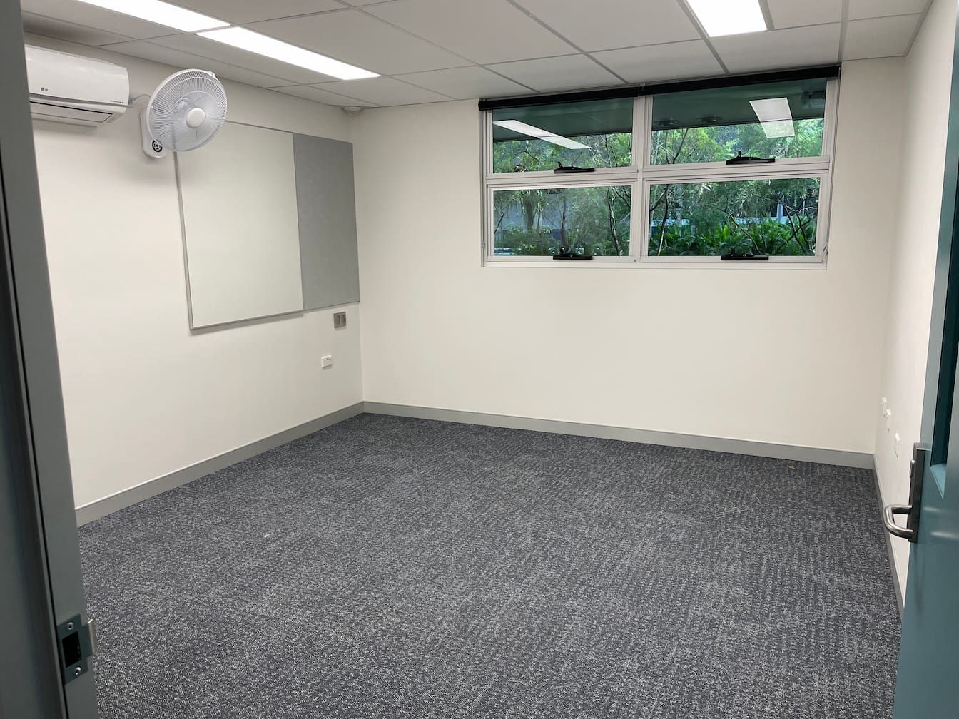 an empty room with a fan hanging from the ceiling