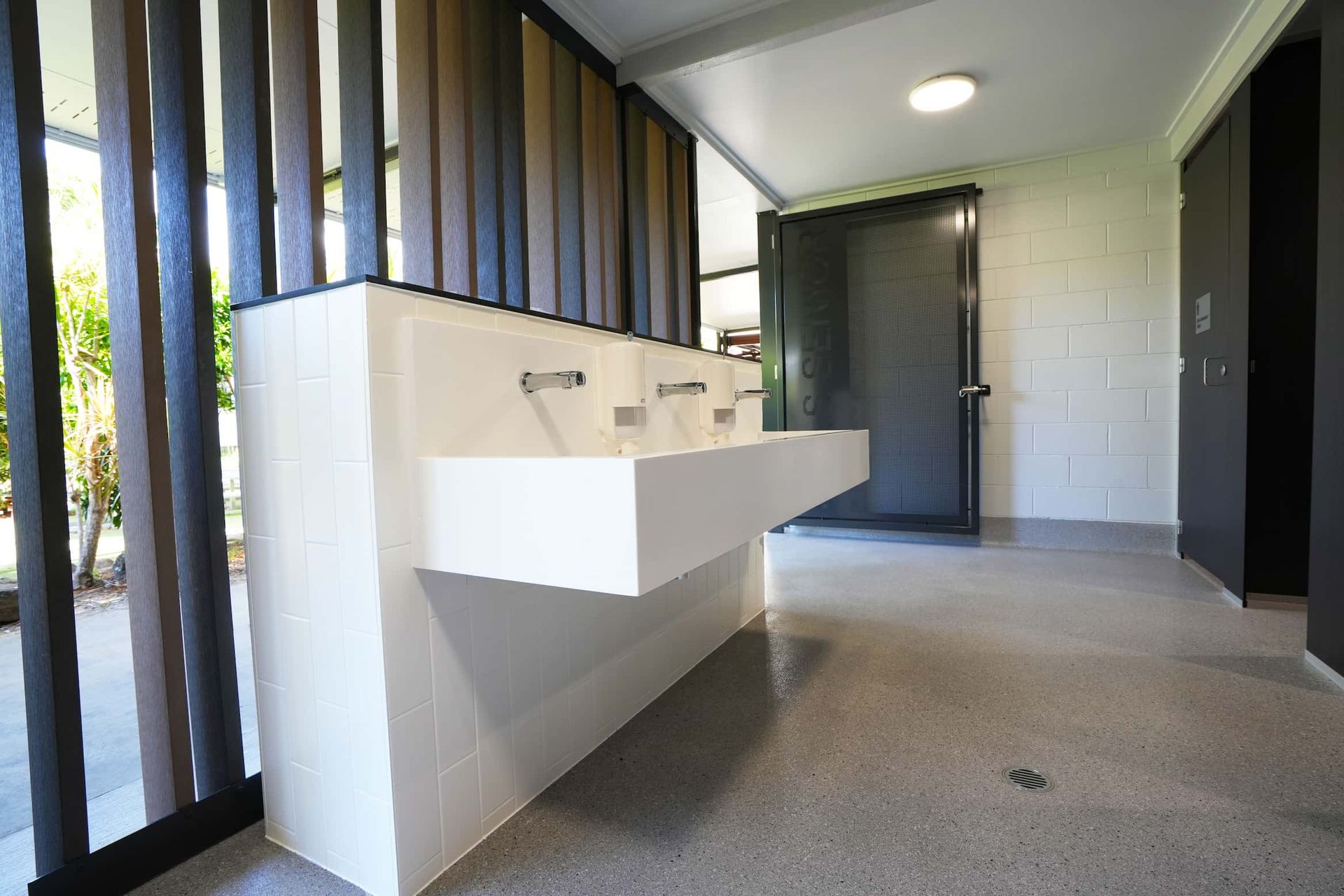 a bathroom with two sinks and a screen door