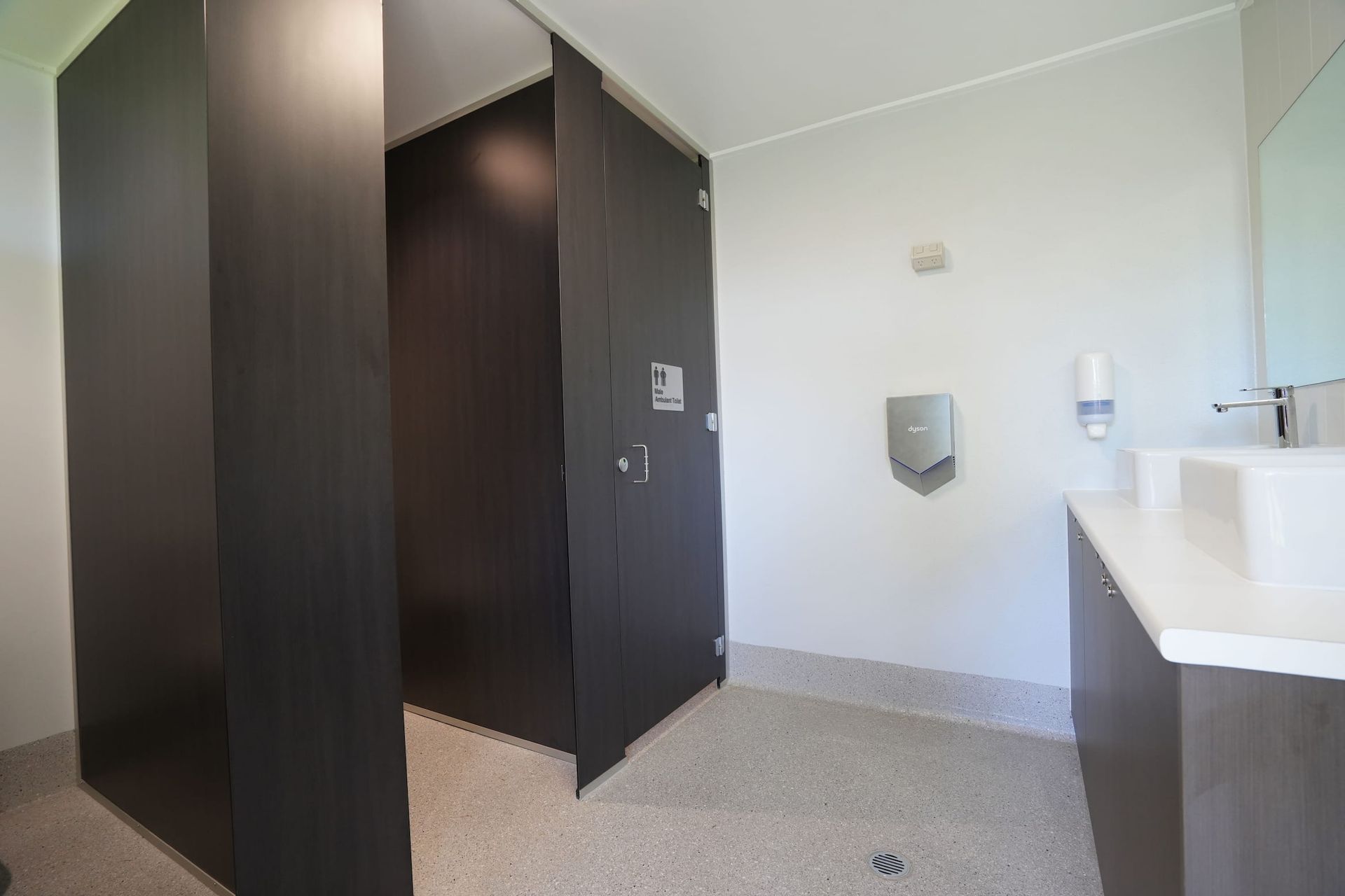 a bathroom with a soap dispenser and a sink