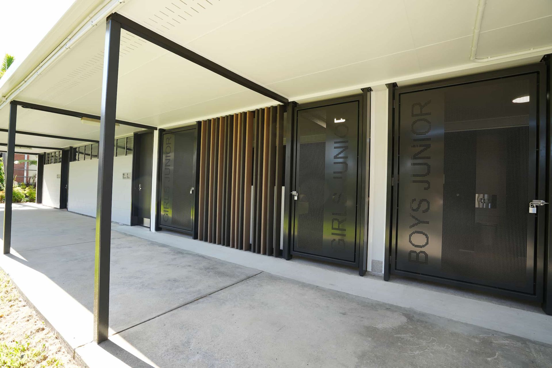 a row of toilet doors with boys junior written on them