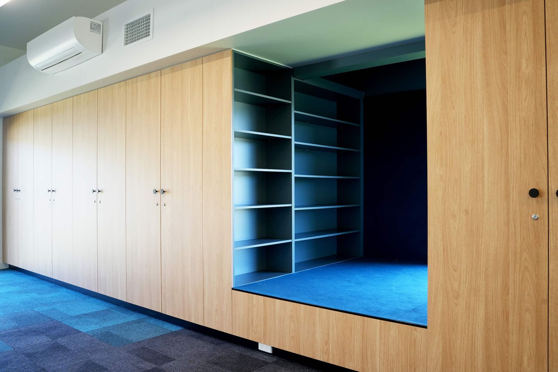 a corner of a room with shelves and lockers