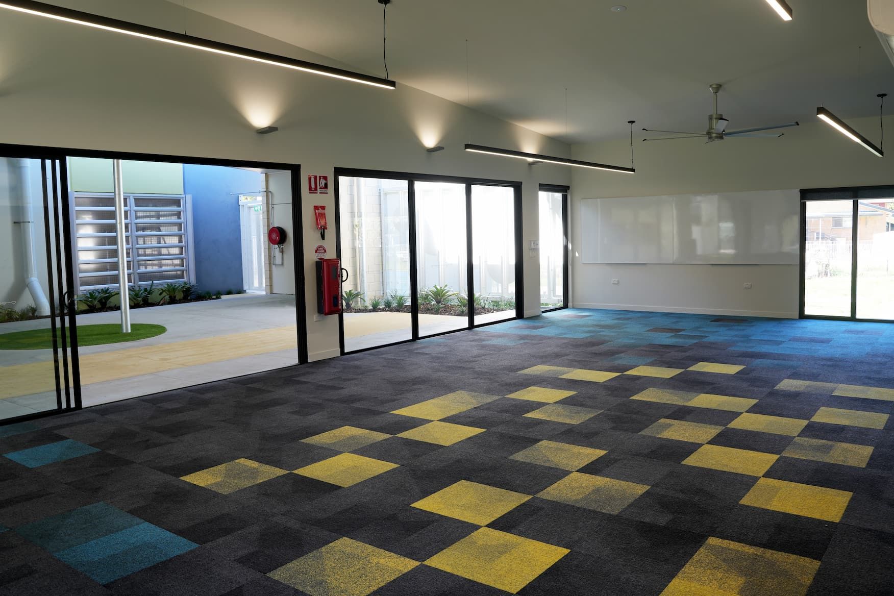 an empty room with a fire extinguisher on the wall