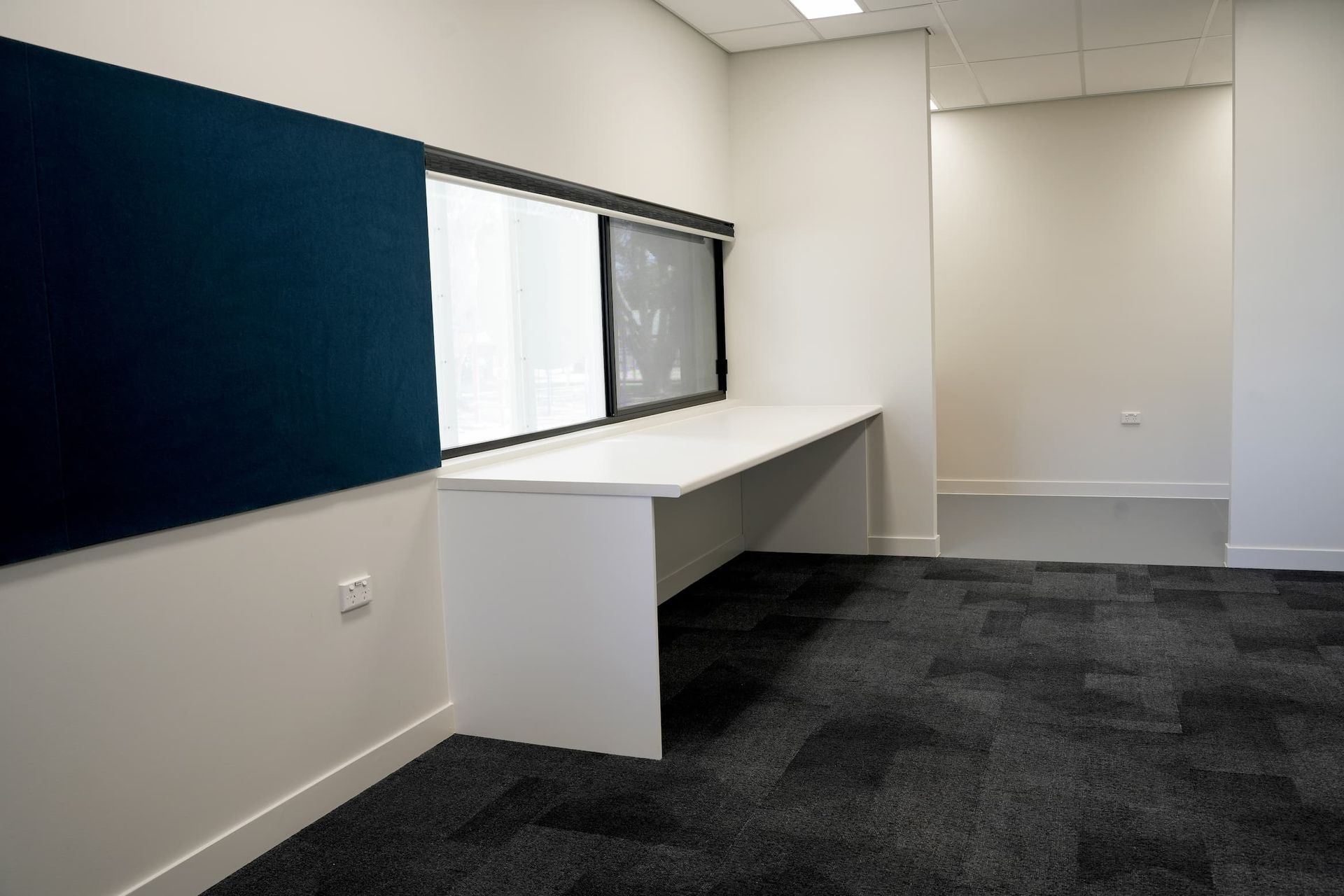 an empty room with a desk and a window
