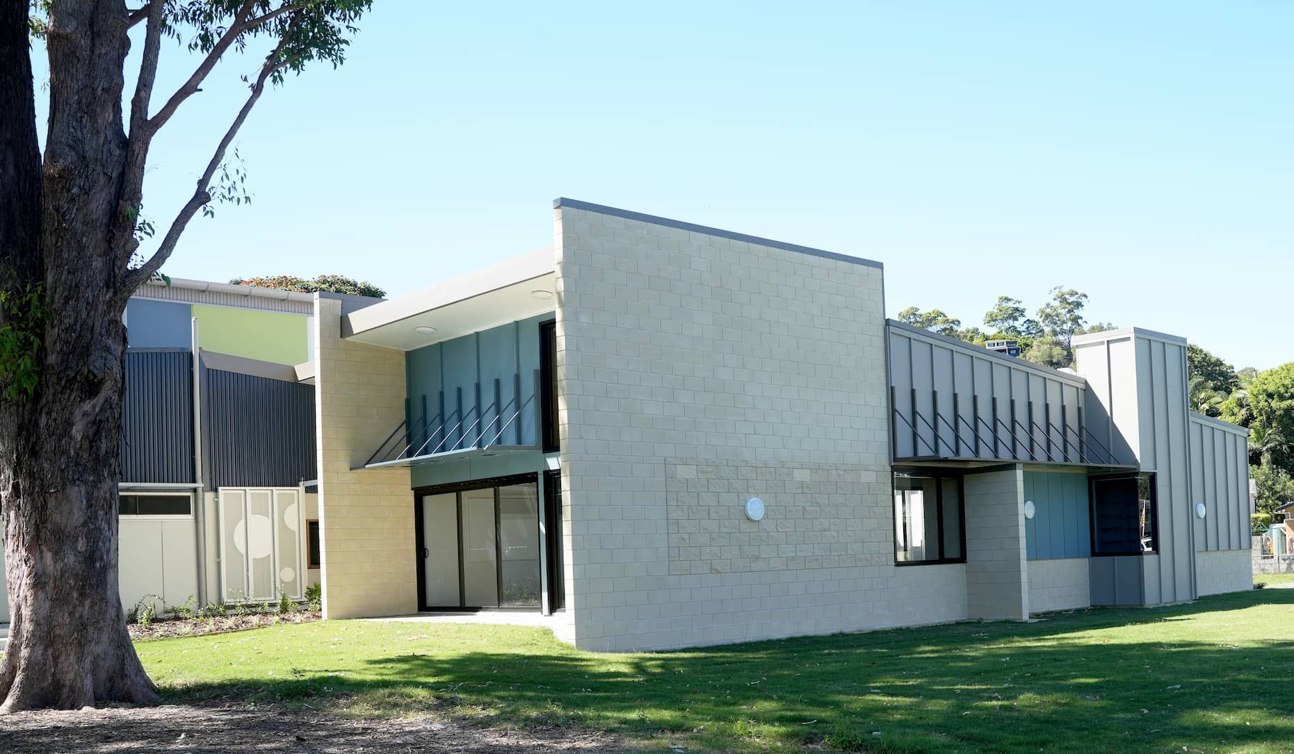 a large school building with a tree in front of it